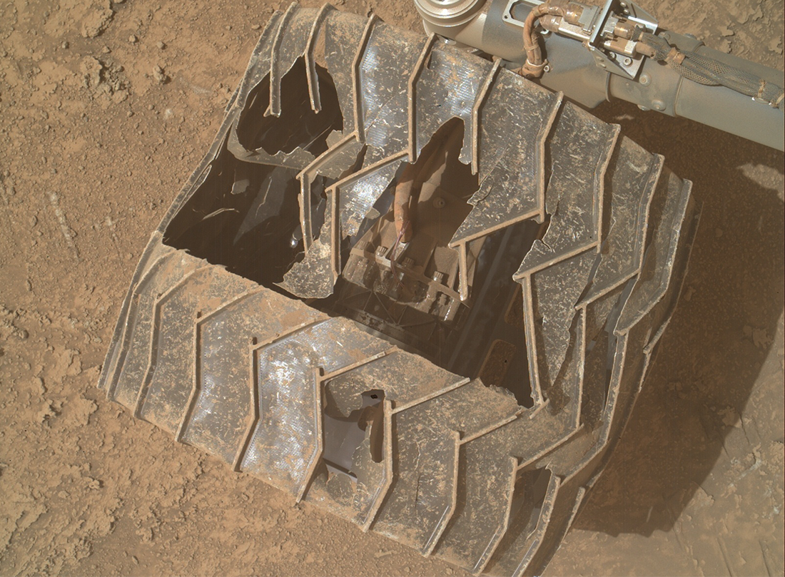 Curiosity's wheel, looking severely damaged. Internal components can be seen through the wheel. Curiosity's wheel, looking severely damaged. Internal components can be seen through the wheel.
